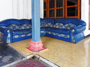Un rincón amoblado con dos sofás azules y un pilar central.