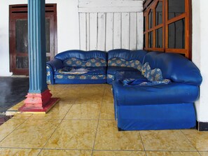 Un sofá azul con tapicería floral en una habitación con suelo de baldosas.