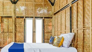 A room with a bed, a window, and a wall with a woven pattern. - OYO Homes 91067 Desa Wisata Santanamekar (Cisayong)