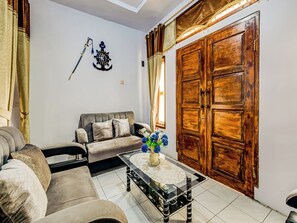 Ein Wohnzimmer mit einer Couch, einem Couchtisch und einer Holztür.