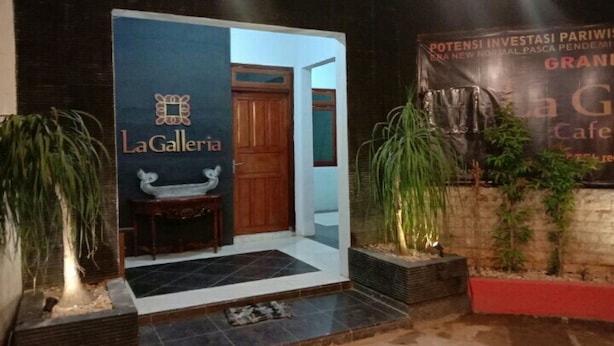 A hotel entrance with a sign for 'LaGalleria' and a banner for 'Grand Cafe'. - OYO 91179 Hotel Lagalleria (Sumenep)