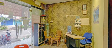 A room with a reception desk, chairs, a water dispenser, and a calendar on the wall.