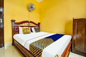 A bed with a wooden headboard, a white mattress, and patterned bedspread. - OYO 91242 Desa Wisata Cibuntu Kuningan Syariah (Mandirancan)