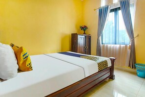 A bed with a wooden frame, a nightstand with a vase, and a window with curtains. - OYO 91242 Desa Wisata Cibuntu Kuningan Syariah (Mandirancan)