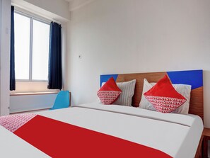Une chambre d’hôtel avec un lit, une fenêtre avec des rideaux et une vue sur l’extérieur.