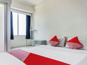 Une chambre d’hôtel moderne équipée d’un lit, d’un bureau et d’une fenêtre avec des rideaux.