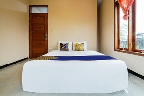 A bedroom with a large bed, a wooden door, and a window with curtains. - OYO 91008 Tourismdesacibodasbabakangentong1syariah (Lembang)