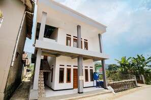 A two-story building with a flat roof, a staircase leading to the upper floor, and a signboard on the ground floor. - OYO 91008 Tourismdesacibodasbabakangentong1syariah (Lembang)