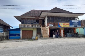 A two-story building with a signboard for 'Kios' and 'AMCOMIN'. - OYO Homes 91248 Desa Wisata Banding Agung Danau Ra (Banding Agung)