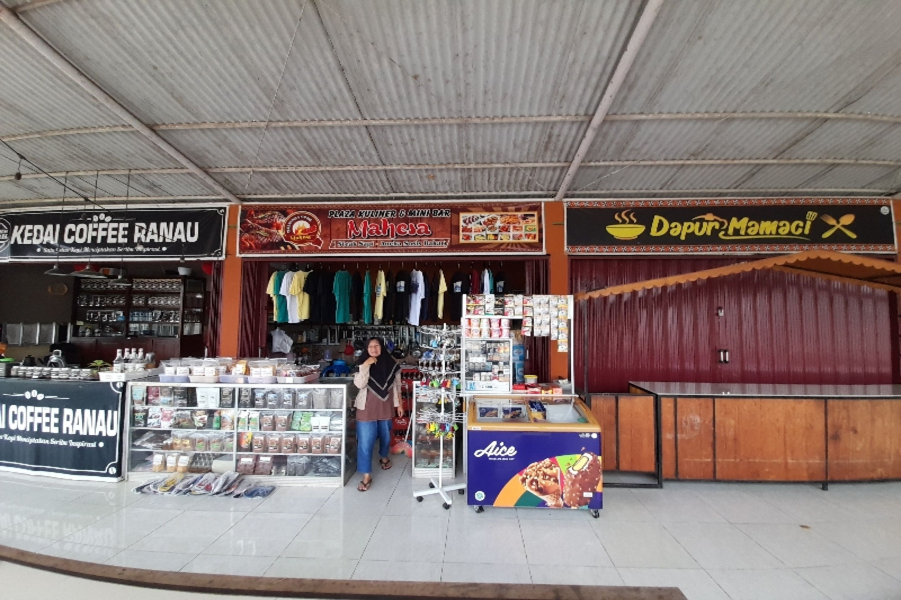 A street market with various stalls, including a coffee shop and a food stall.