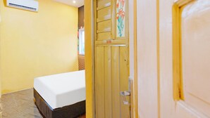 A room with a bed, a door with a CSF door sign, and an air conditioning unit on the wall. - OYO 90977 Wisma Pelangi Palopo (Palopo)