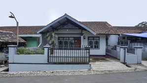 A residential house with a tiled roof, a gated entrance, and a small porch. - OYO 91011 Eco Tourism Desa Cibodas Areng 1 Syariah (Lembang)