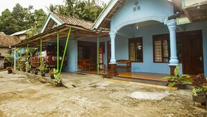 A traditional building with a blue facade, a tiled roof, and a porch with wooden benches. - OYO 91089 Desa Wisata Air Terjun Way Kalam Syariah (Kalianda)