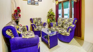 A living room with purple armchairs, a glass coffee table, and a potted plant. - OYO 91089 Desa Wisata Air Terjun Way Kalam Syariah (Kalianda)