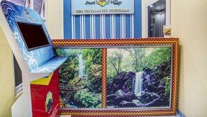 A public service building with a sign reading "PELAYANAN PUBLIK" and "Smart Village" along with a scenic waterfall image. - OYO 91089 Desa Wisata Air Terjun Way Kalam Syariah (Kalianda)