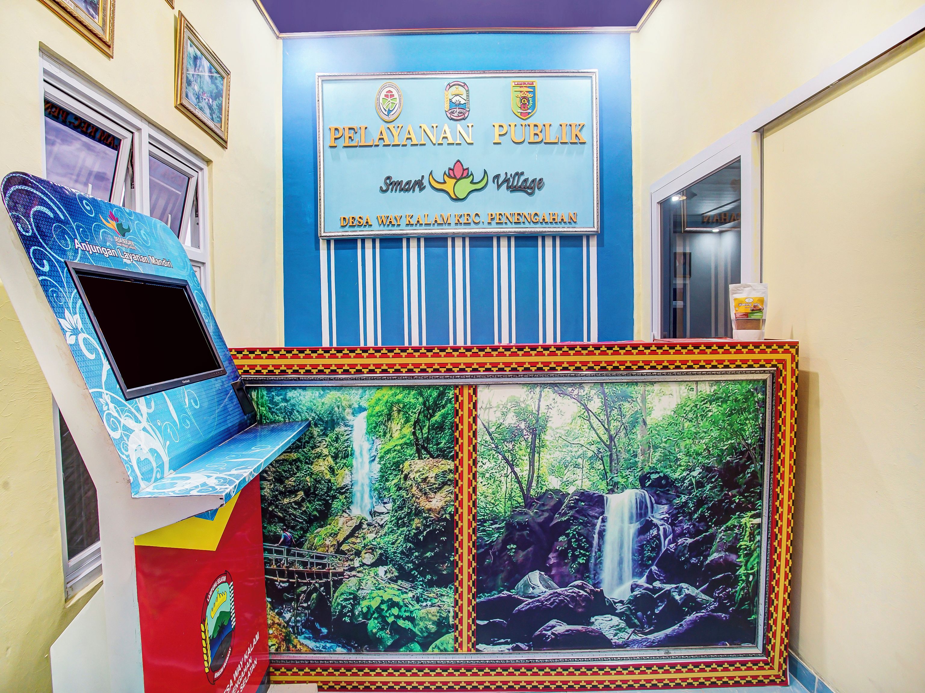 A public building with a sign reading 'PELAYANAN PUBLIC' and a mural of a waterfall.