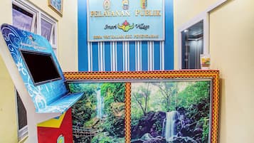 A public building with a sign reading 'PELAYANAN PUBLIC' and a mural of a waterfall.