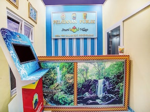 A public building with a sign reading 'PELAYANAN PUBLIC' and a mural of a waterfall. - OYO 91089 Desa Wisata Air Terjun Way Kalam Syariah (Kalianda)