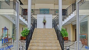Un hall d’hôtel doté d’un escalier central, de plusieurs étages et d’un design moderne.