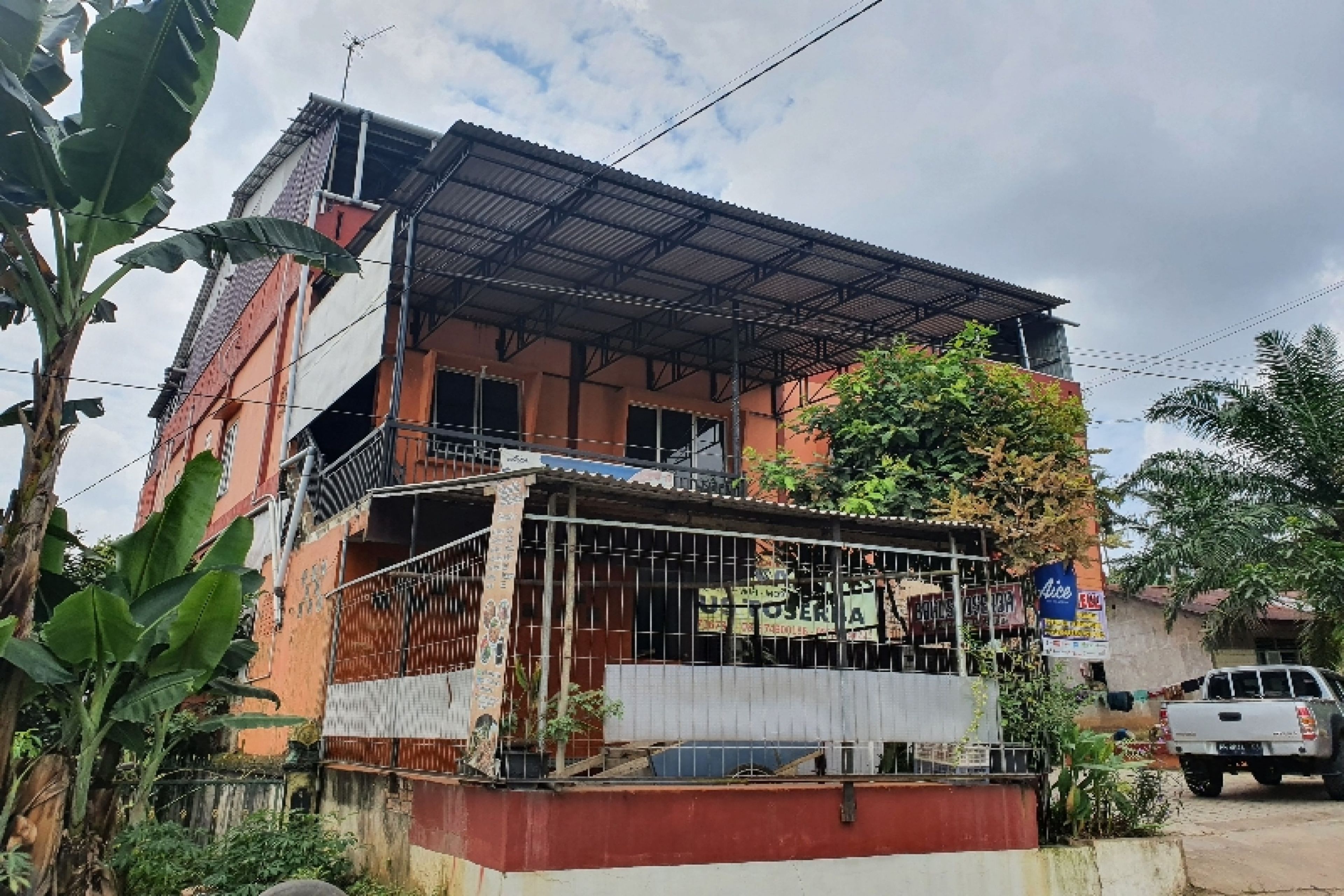 A two-story building with a metal roof and a balcony.
