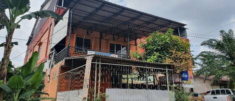 A two-story building with a metal roof and a balcony.