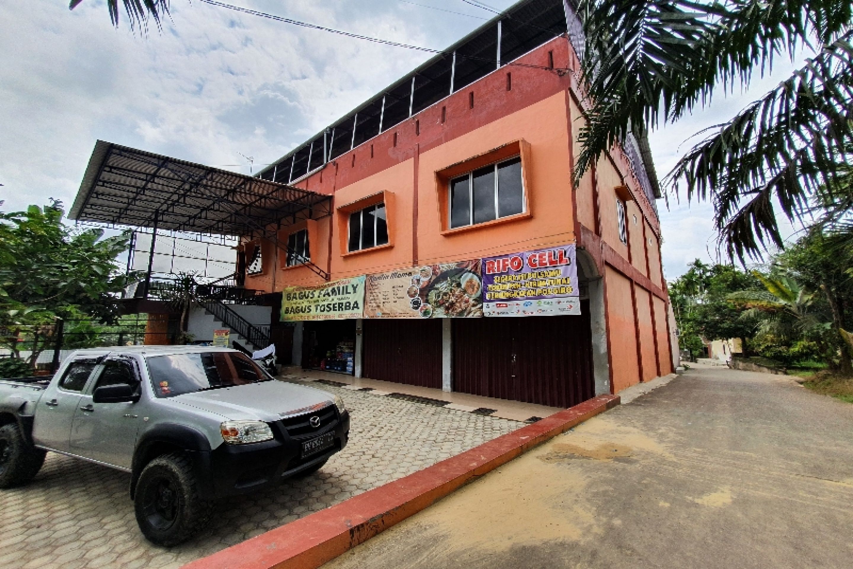 Un edificio con un cartel que dice "RIFO CELLAR" y "BAGUS FAMILY BAGUS TOSERBA".