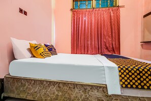A bed with a patterned bedspread, pillows, and a headboard. - OYO Homes 91124 Desa Wisata Kaso (Kaso)