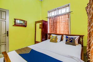 A room with a bed, a window with curtains, a door, and a mirror on the wall. - OYO Homes 91124 Desa Wisata Kaso (Kaso)