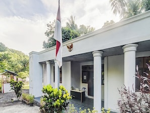 Ein Gebäude mit Fahnenmast, Säulen und einer Tür.