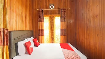 A wooden-paneled room with a bed, curtains, and a clock on the wall.