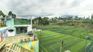 Un campo deportivo con un edificio que dice 'TATA TERTIB' al frente.