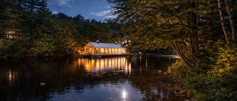 A lakeside lodge with a dock, surrounded by dense forest.