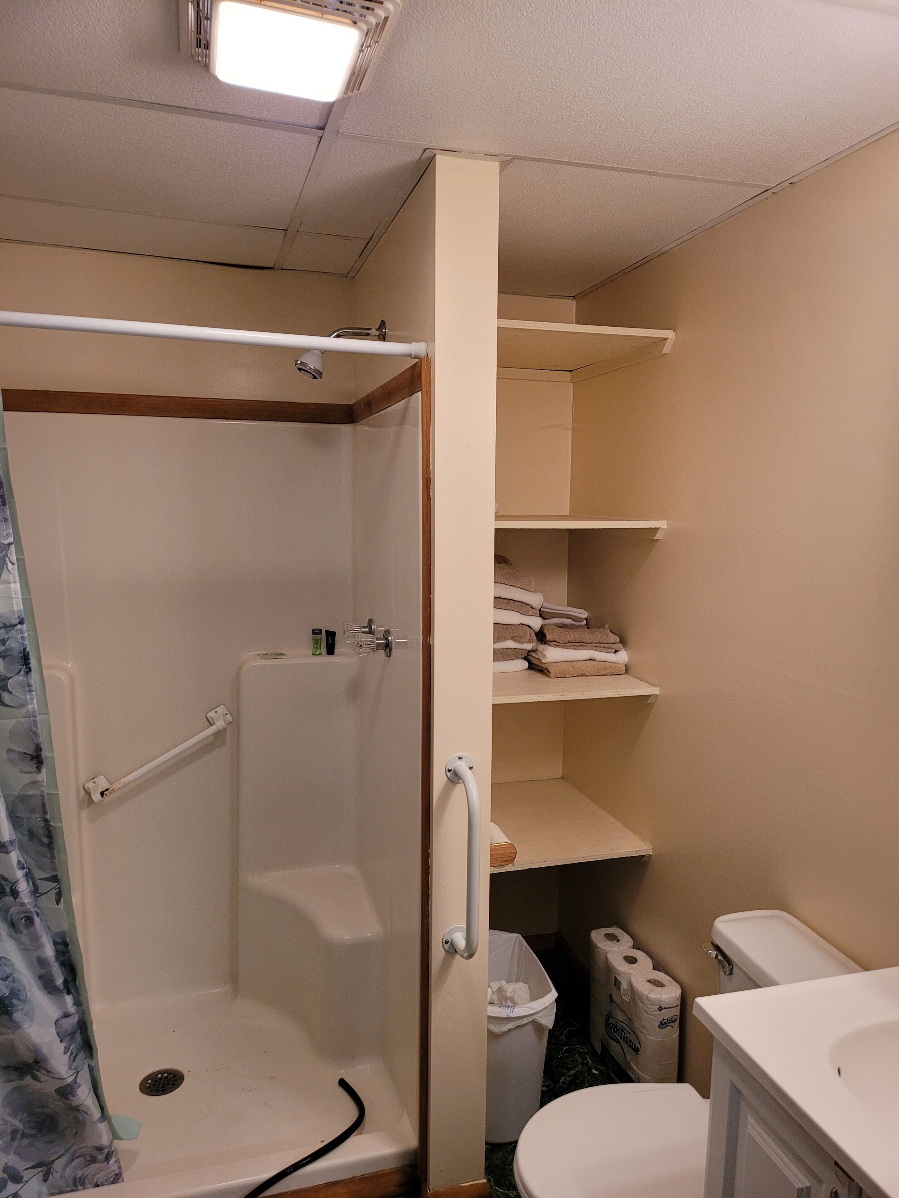 Ein Badezimmer mit Dusche, Toilette und Ablageflächen.