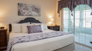 Une chambre à coucher avec un grand lit, une table de chevet, une lampe, une fenêtre avec des rideaux et un tableau accroché au mur.