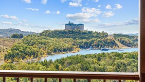 A hotel on a hill with a view of a river and surrounding forest. - Lakeview Penthouse 4BR/4BA Condo • Sleeps 12 • Sunroom + Balcony (Branson)