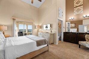 A bedroom with a bed, a dresser, a vanity, and a chair. - Lakeview Penthouse 4BR/4BA Condo • Sleeps 12 • Sunroom + Balcony (Branson)