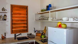 Una cocina con un armario de madera, un lavabo, una estufa y un refrigerador.