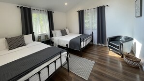 Ein modernes Schlafzimmer mit zwei Betten, einem Sofa und einem Fenster mit Vorhängen.