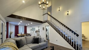 Ein geräumiger Wohnbereich mit einer großen Couch, einem Couchtisch und einer Treppe.
