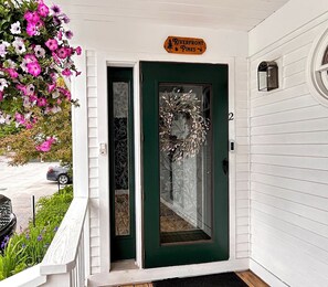 Une maison avec une porte verte, une enseigne indiquant « Riverfront Pines », et une couronne décorative accrochée à la porte.