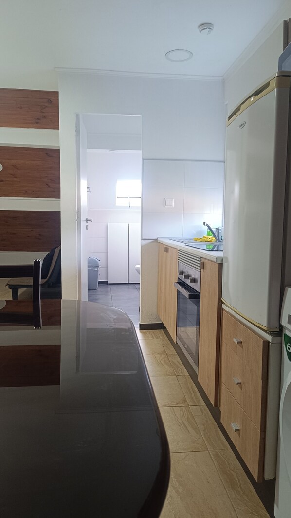 Una cocina moderna con una mesa de comedor de madera, armarios y un refrigerador.