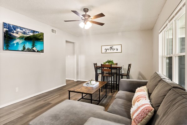 A living room with a ceiling fan, a dining table with chairs, a sofa, and a wall-mounted picture. - 2bed/1bath apt w/ full kitchen - central location! (Arlington)
