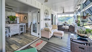 A spacious living area with a kitchen, dining area, and a view of the outdoors.