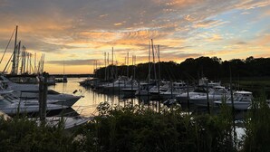 Ein Yachthafen mit vertäuten Booten, umgeben von Grünflächen und Bäumen.