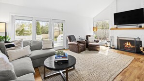 Ein modernes Wohnzimmer mit einer Eckcouch, einem Couchtisch und einem Kamin.