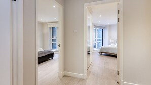 Une chambre à coucher moderne avec un grand lit, une table de chevet et une fenêtre.