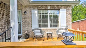 A brick house with a wooden deck, two wicker chairs, a small table, and a lantern. - Charming Springfield Escape w/ Furnished Deck (Springfield)