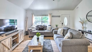A living room with a sofa, coffee table, TV, and a ceiling fan. - Charming Springfield Escape w/ Furnished Deck (Springfield)