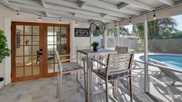 A covered patio with a pool, a table with chairs, and a fan. - 8 Mi to Beaches: Bradenton Home w/ Poolside Oasis! (Bradenton)