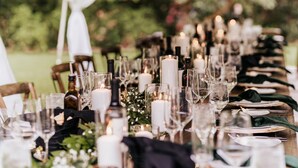 A table set for a formal event with candles, glassware, and plates.
